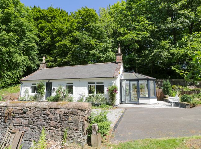 A house with a conservatory and garden area at Nithbank Cottage