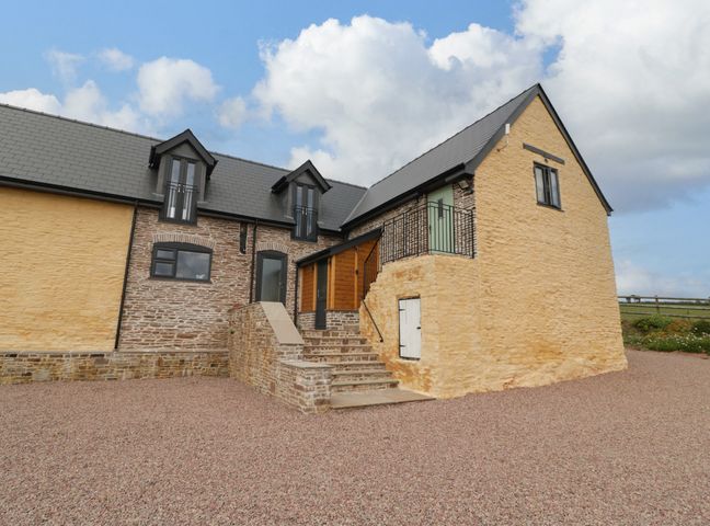 The exterior of a stone farmhouse with steps leading to the entrance at Palace Farmhouse in St Weonards