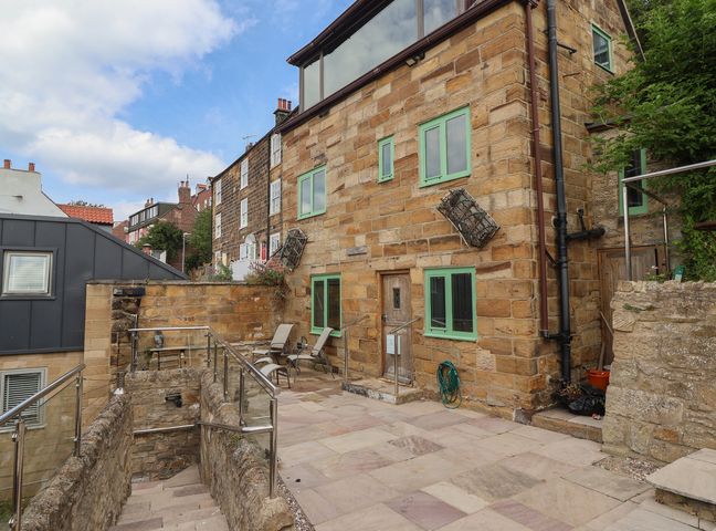 An outdoor area with a stone building and patio at 5 Hall Yard in Whitby