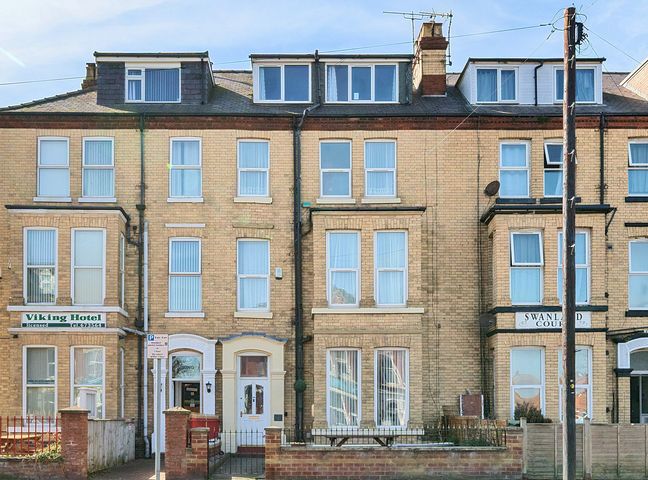 A row of brick buildings with multiple windows including Viking Hotel and Swanland Court at Bridlington Bay House in Bridlington