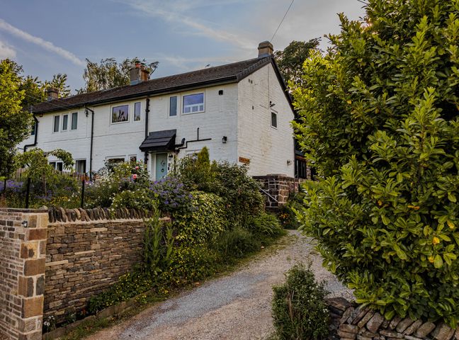 A house with a driveway and garden at Wells Cottage in Holmfirth