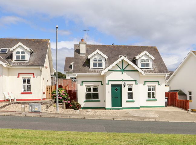 A street view of houses with dormer windows and green and red trim at South Beach in Duncannon County Wexford