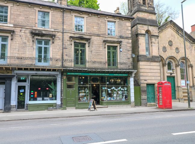 A street view with shops and a red phone box at The Old Apothecary in Matlock Bath near Matlock
