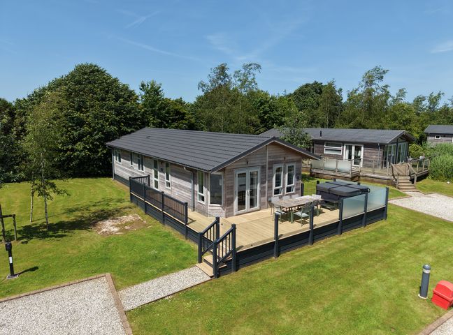 A lodge with decking and garden area at 4 Meadow Retreat in Dobwalls
