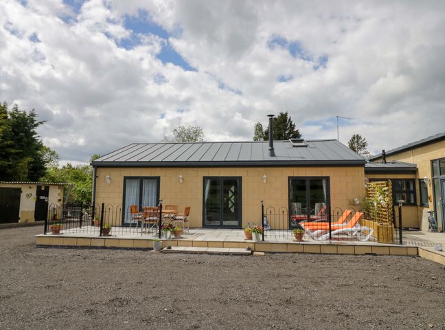 A house with patio and chairs at The Barn in Astwood Bank