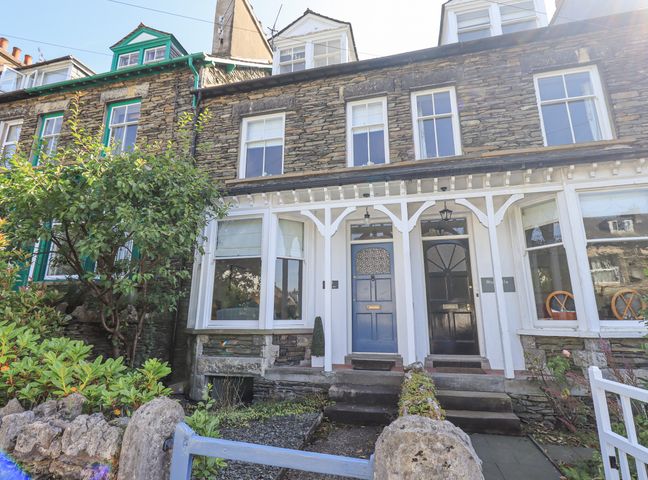 Stone terraced houses with bay windows and a garden in front at The Thistles in Bowness-On-Windermere