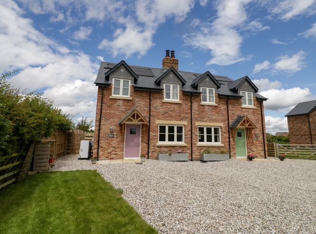 A brick semi detached house with two entrances and gravel driveway at Daisy Cottage in Oxhill near Tysoe