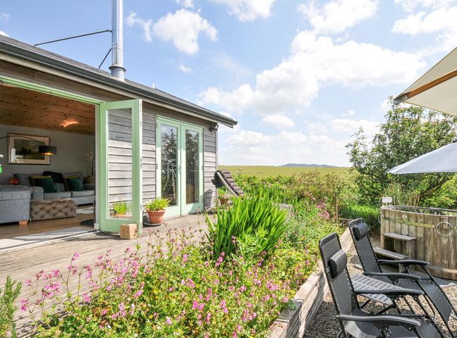 An outdoor area with seating and flowers at Smugglers Bodmin Moor, St Breward near St Tudy