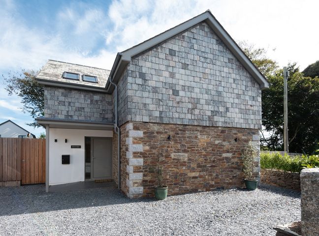 A house with stone wall and shingle roof at Pentire in St Minver