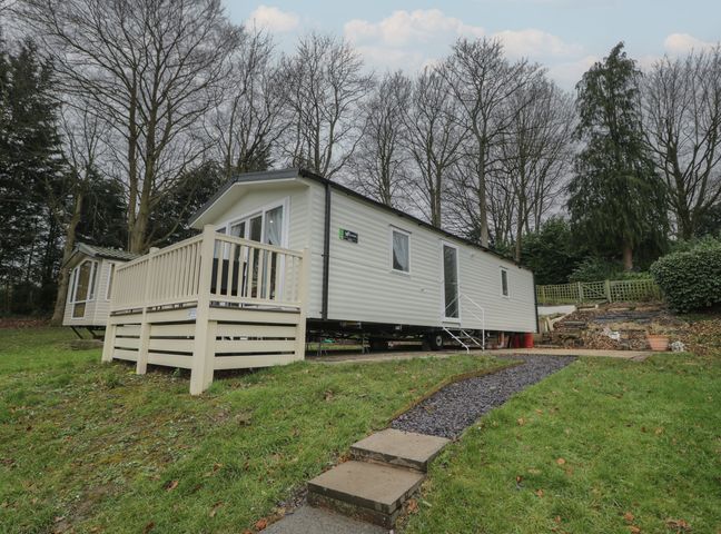 A mobile home with steps and decking in an outdoor area at Woodlands Platinum (WO29) in Ruthin