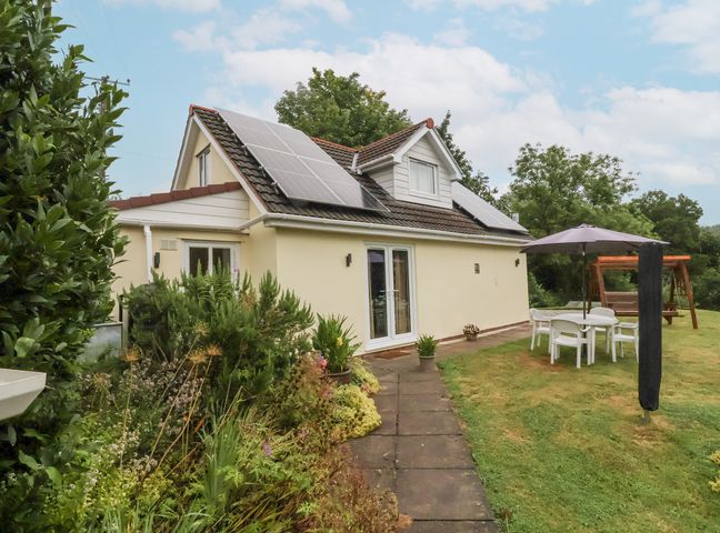 A house with solar panels and garden furniture at Hideaway in Great Torrington