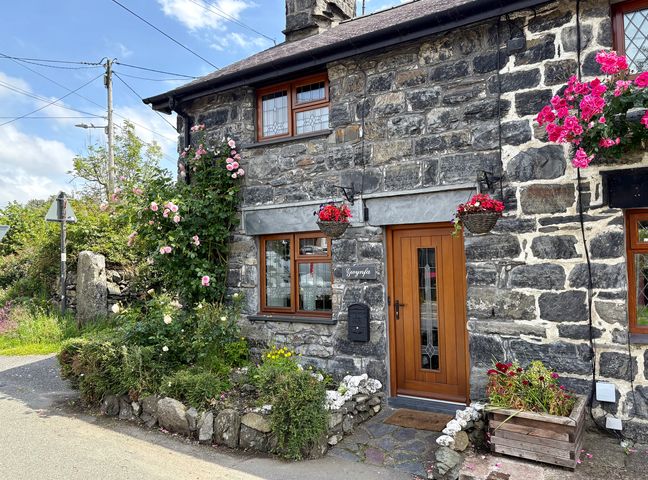 The entrance of Gwynfa with flowers and stone features in Ysbyty Ifan
