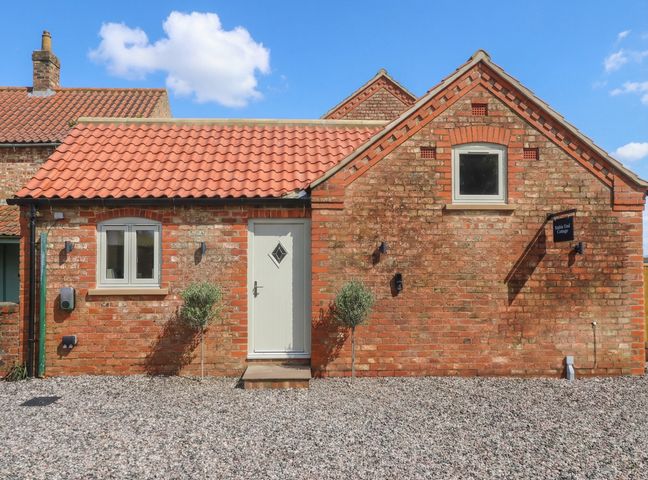 A cottage exterior with a gravel pathway at Stable End Cottage near Wilberfoss