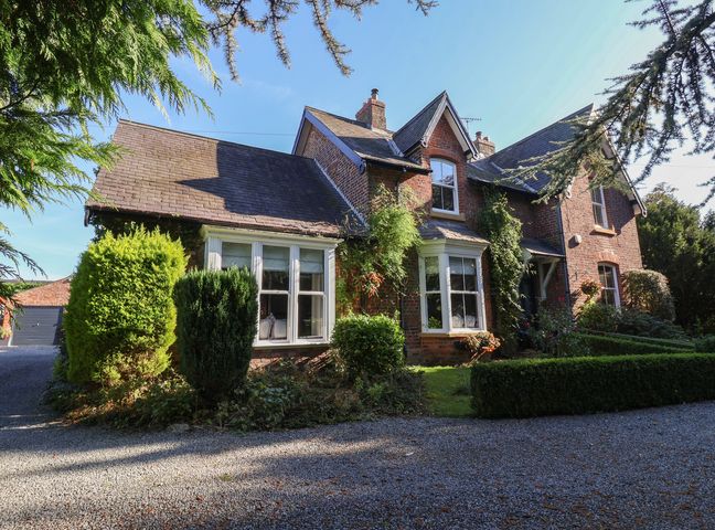 A house with a gravel driveway and garden at Ten Gables in Driffield