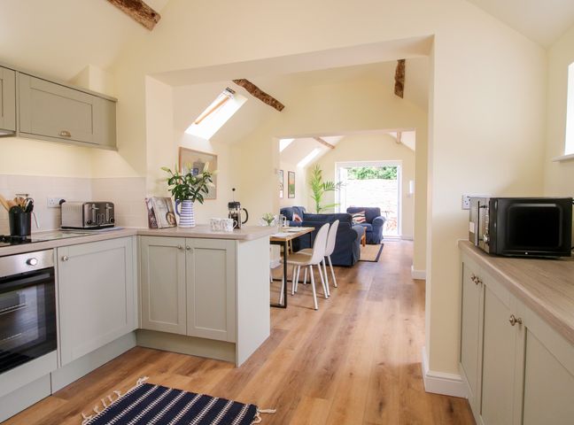 A kitchen with appliances and dining area at The Old Piggery in Shifnal