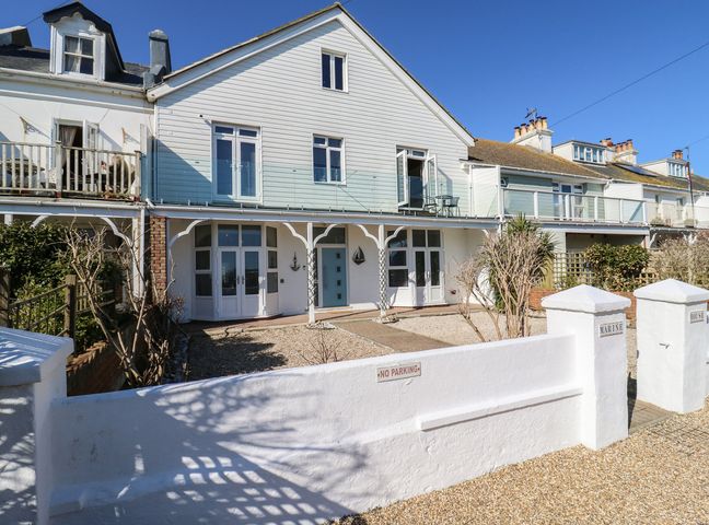 A white two-story house with a gravel front yard and a no parking sign at Marine House in Pevensey Bay