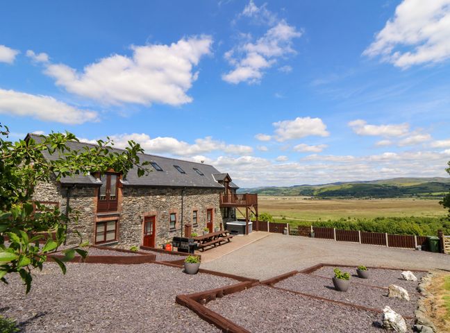 A stone house with outdoor seating and views at Llwyngwinau Isaf Barn Tynreithyn near Tregaron