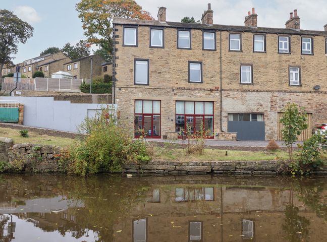 A building with windows by a canal at Canal Side in Skipton