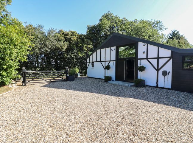 An entrance view of a house with a gravel driveway at The Old Workshop Wormshill near Harrietsham