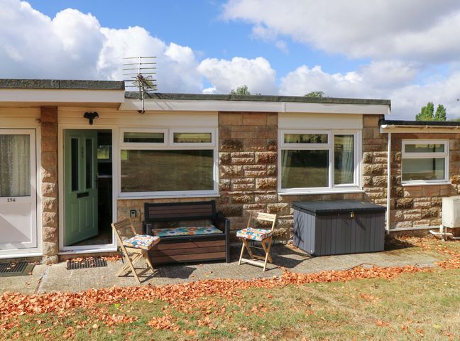 An outdoor area with a bench and chairs at No 157 Sandown Bay Holiday Chalet 'Field View' in Sandown