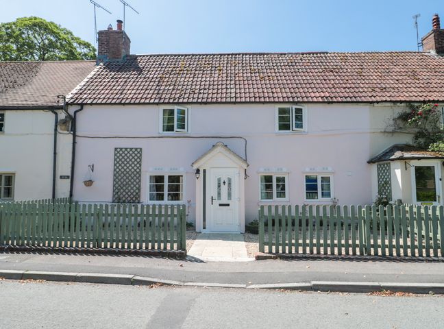 A house with a fence and door at Old Farm Cottage in Warminster