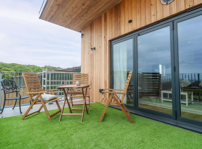 An outdoor seating area with wooden furniture at Swallows Nest in St. Ives