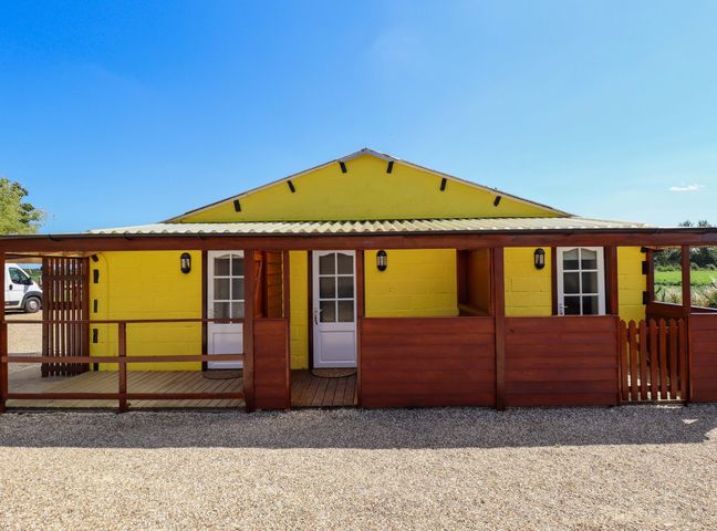 A yellow building with a wooden porch and two doors at Dakota