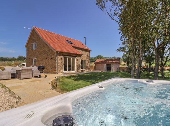 An outdoor area with furniture and a hot tub at The Fox Den in East Coker