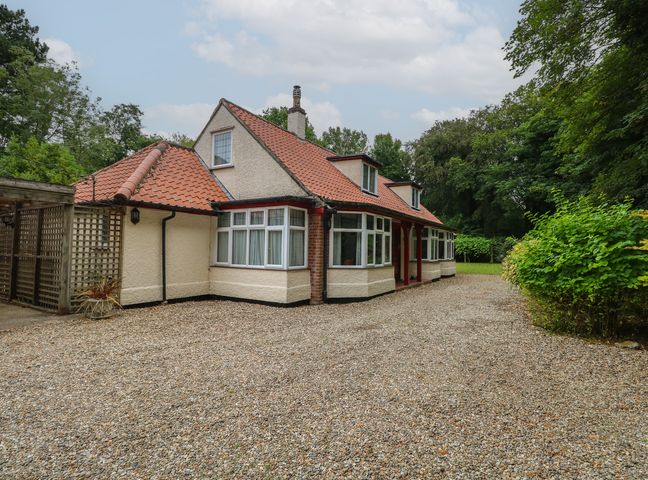A house with a driveway and garden at The Anchorage in Hoveton & Wroxham