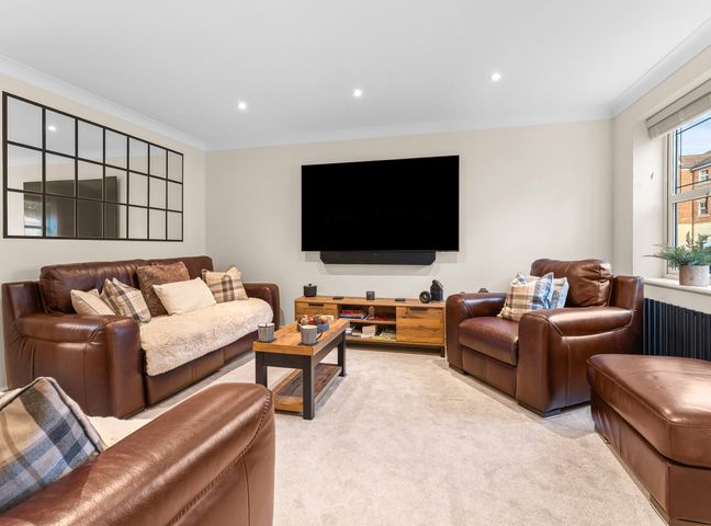 A living room with leather sofas and a television at Hafan Rhos in Rhos-On-Sea