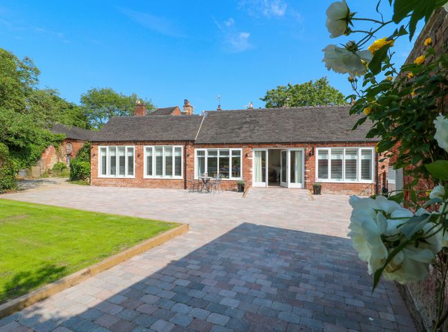 An outdoor area with a house and patio at The Canalside Cottage in Derby
