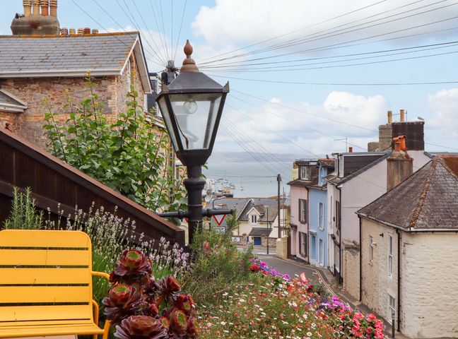 A view of houses and flowers with a lamp post in Captains Cottage in Brixham