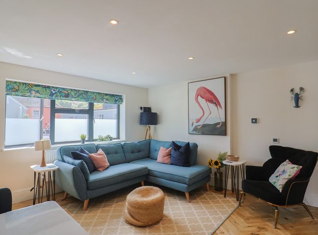 A living room with a sofa and artwork at 1 Mill Green Court Lyme Regis