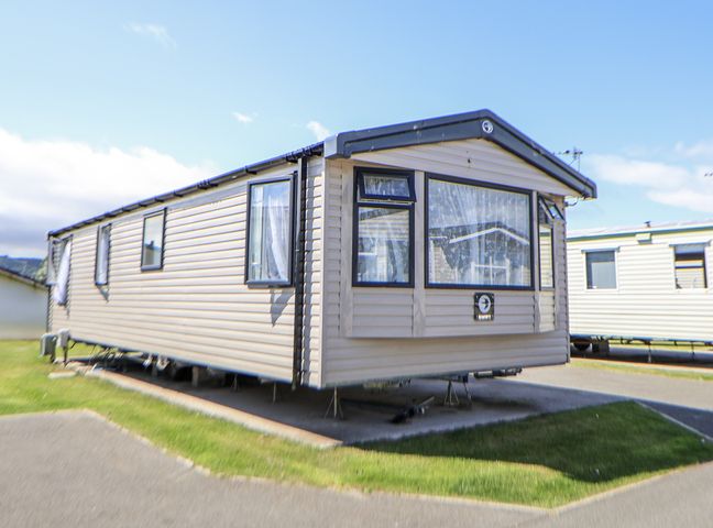 A caravan parked on a grassy area at V9 Ty Mawr Holiday Park