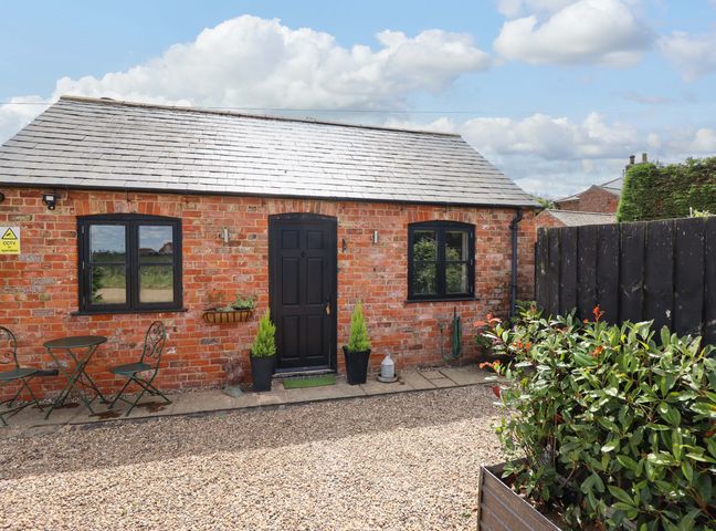 A cottage exterior with outdoor furniture and plants at The Paw Barn in Scrane End near Boston