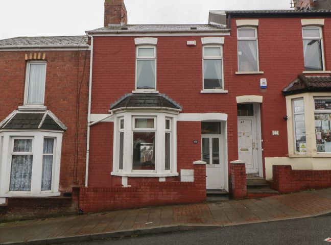 A red house with windows and door at Gavin and Stacey House in Barry