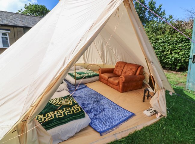 A tent with a sofa and beds at Bell Tent Three