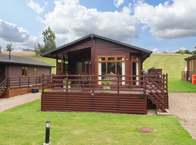 A cabin with a deck and grassy area at Badgers Retreat - Two Dales Richmond