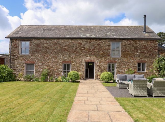 A house with a garden pathway and seating area at Duke's Barn in Blackawton near Dartmouth