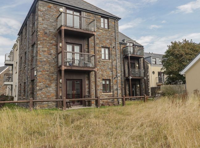 A building with balconies and grass area at Awel y Môr in Burry Port