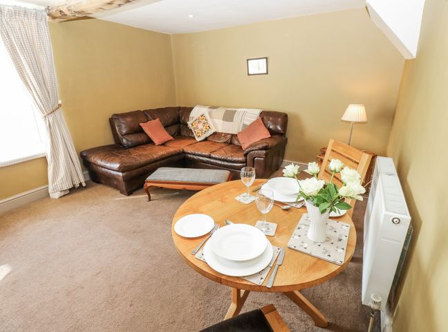 A living room with a sofa and dining table at Ewe Cottage in Ripon