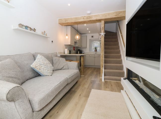 A living room with a sofa and table at 61A High Street in Criccieth