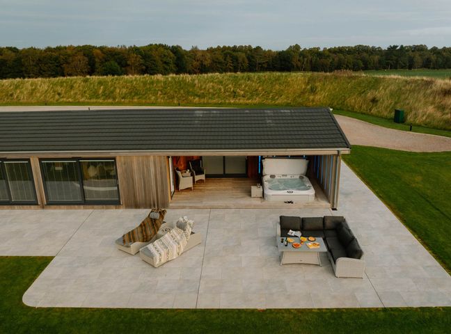 A patio with a hot tub and outdoor seating area at The Sheraton Retreat in Wigton