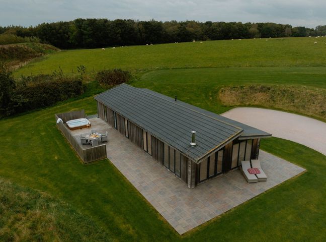 A hut with a hot tub and patio furniture at Wellington in Wigton