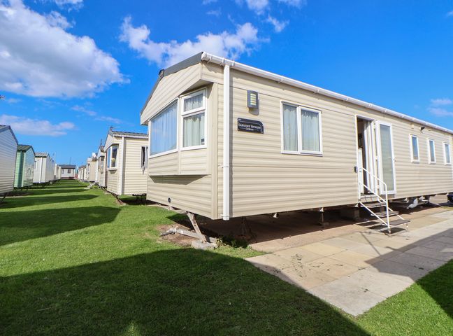 A caravan with a sign outside at E10 Static Caravan Rhyl