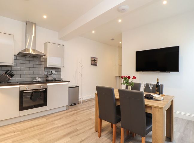 A kitchen with modern appliances and dining table at West Chambers in Camborne