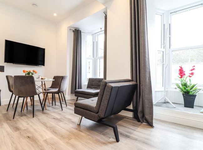 A living room with a sofa and dining table at Baker Chambers in Camborne