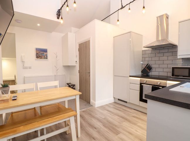 A kitchen with dining table and chairs at Battell Chambers in Camborne