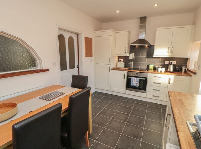 A kitchen with a dining table and chairs at Cliffe Cottage in Brotton, North Yorkshire