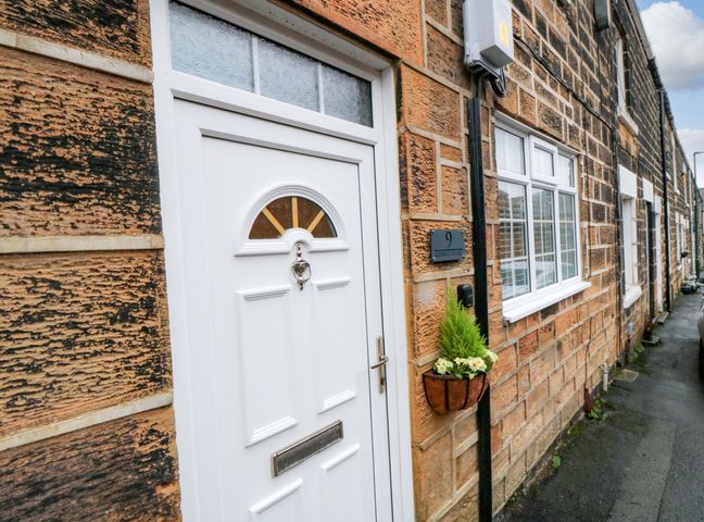 A front door with a window and house number at Cliffe Cottage Brotton, North Yorkshire